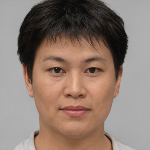 Joyful asian young-adult male with short  brown hair and brown eyes