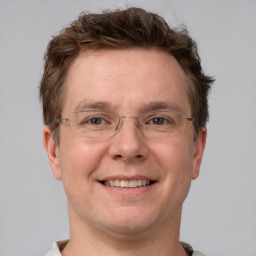 Joyful white adult male with short  brown hair and grey eyes