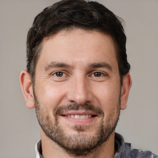 Joyful white adult male with short  brown hair and brown eyes