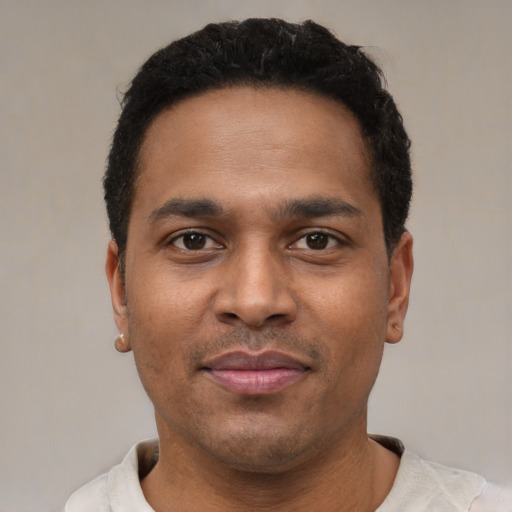 Joyful latino young-adult male with short  black hair and brown eyes