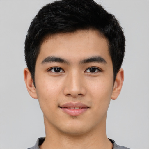 Joyful asian young-adult male with short  black hair and brown eyes