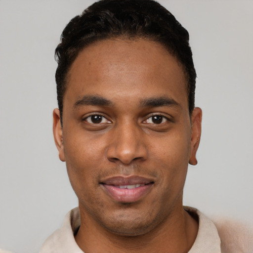 Joyful black young-adult male with short  black hair and brown eyes