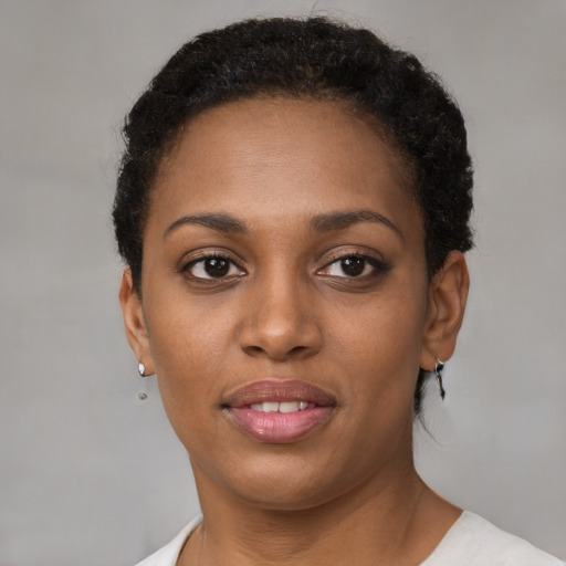 Joyful black young-adult female with short  brown hair and brown eyes