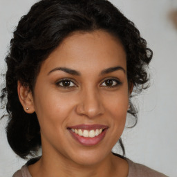 Joyful black young-adult female with long  brown hair and brown eyes