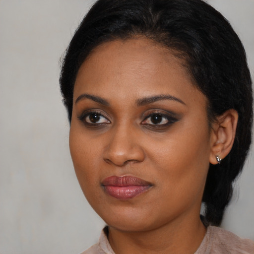 Joyful black young-adult female with medium  brown hair and brown eyes