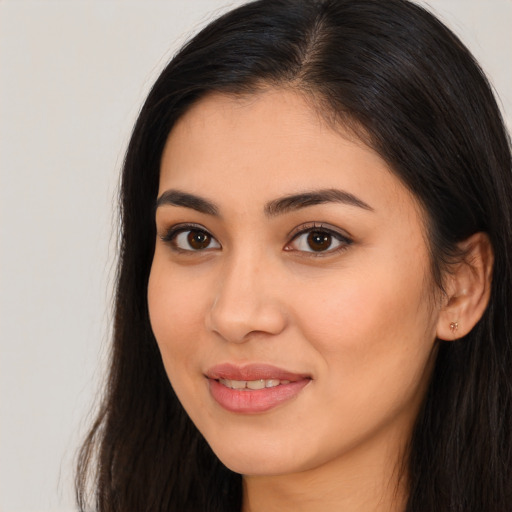 Joyful latino young-adult female with long  brown hair and brown eyes