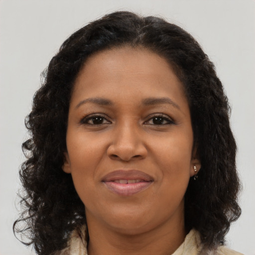 Joyful black young-adult female with long  brown hair and brown eyes