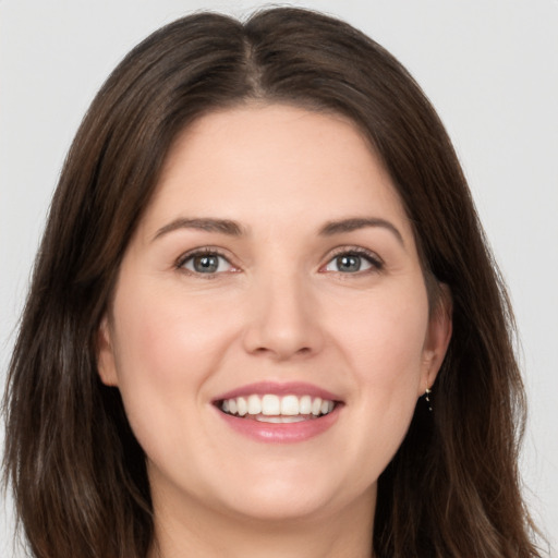 Joyful white young-adult female with long  brown hair and brown eyes