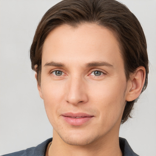 Joyful white young-adult male with short  brown hair and grey eyes