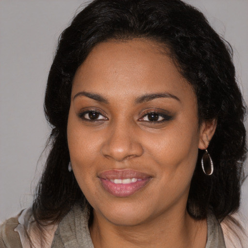 Joyful black young-adult female with long  brown hair and brown eyes