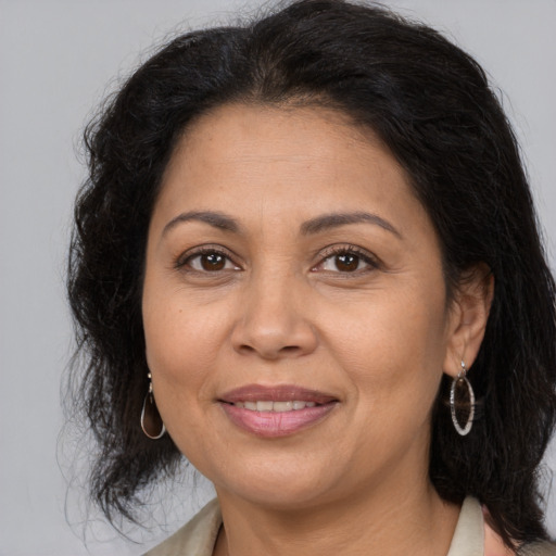 Joyful latino adult female with medium  brown hair and brown eyes