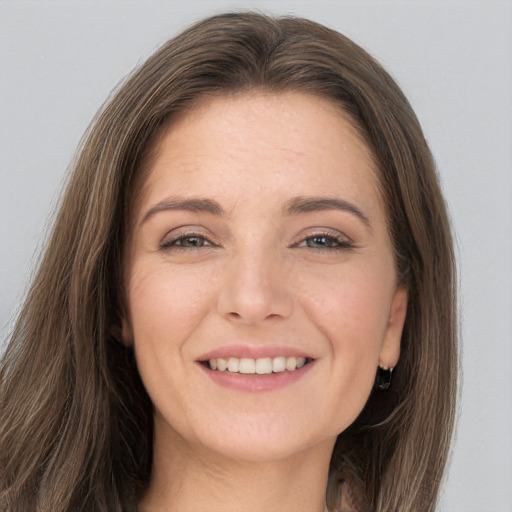 Joyful white young-adult female with long  brown hair and grey eyes