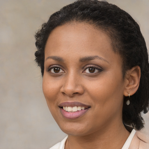 Joyful black young-adult female with short  brown hair and brown eyes