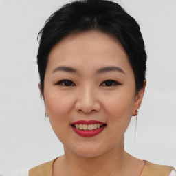 Joyful asian young-adult female with short  black hair and brown eyes