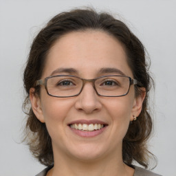 Joyful white adult female with medium  brown hair and grey eyes