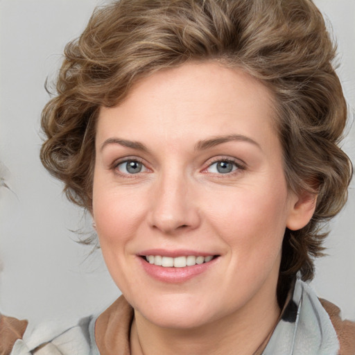 Joyful white young-adult female with medium  brown hair and blue eyes