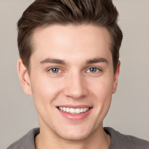 Joyful white young-adult male with short  brown hair and grey eyes