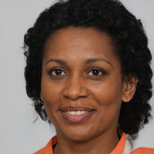 Joyful black adult female with medium  brown hair and brown eyes