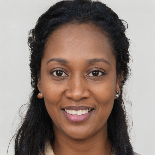 Joyful black young-adult female with long  black hair and brown eyes