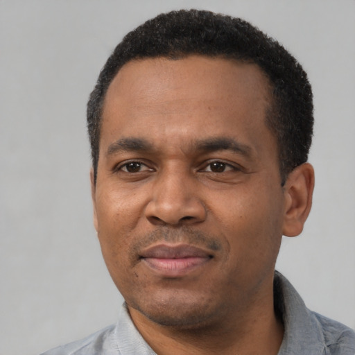 Joyful latino adult male with short  black hair and brown eyes