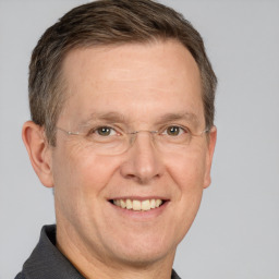 Joyful white adult male with short  brown hair and grey eyes