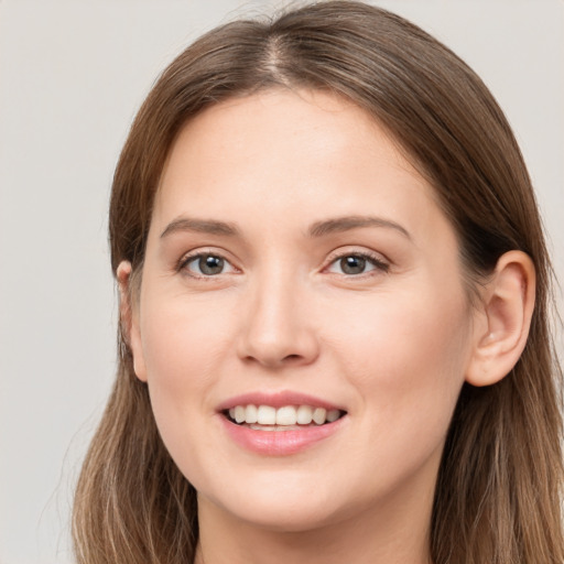 Joyful white young-adult female with long  brown hair and grey eyes