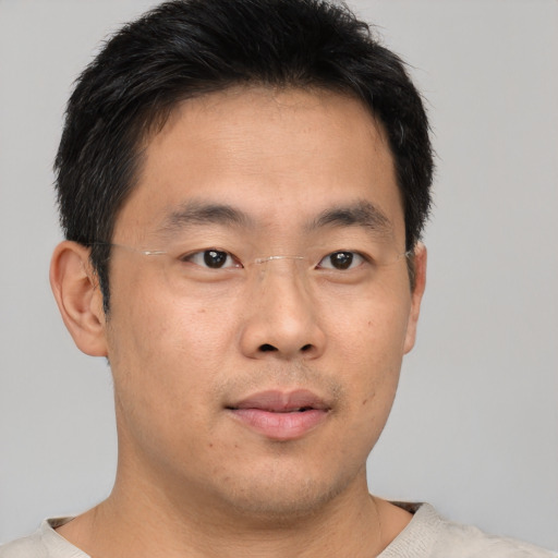 Joyful asian young-adult male with short  brown hair and brown eyes
