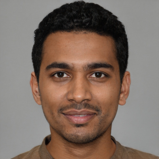 Joyful latino young-adult male with short  black hair and brown eyes
