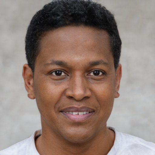 Joyful black young-adult male with short  black hair and brown eyes