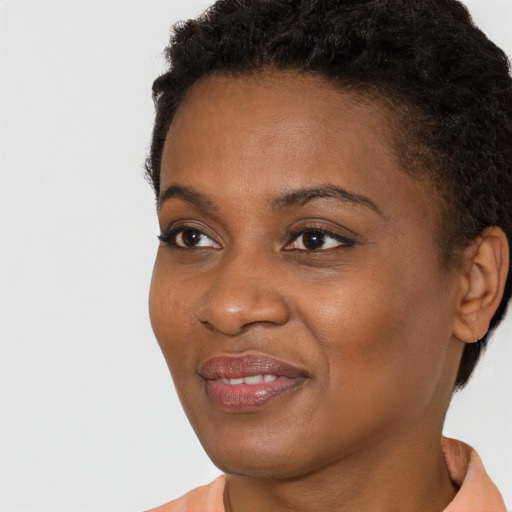 Joyful black young-adult female with short  brown hair and brown eyes