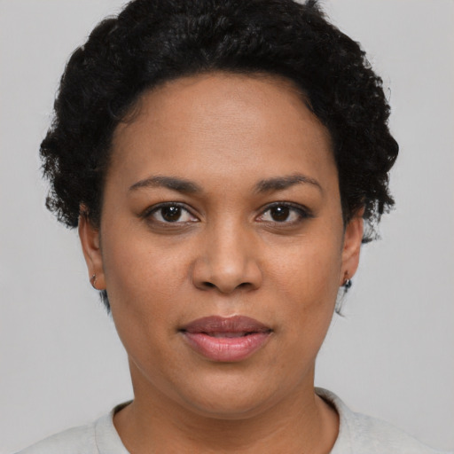 Joyful black adult female with short  black hair and brown eyes