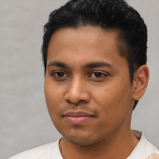 Joyful latino young-adult male with short  black hair and brown eyes