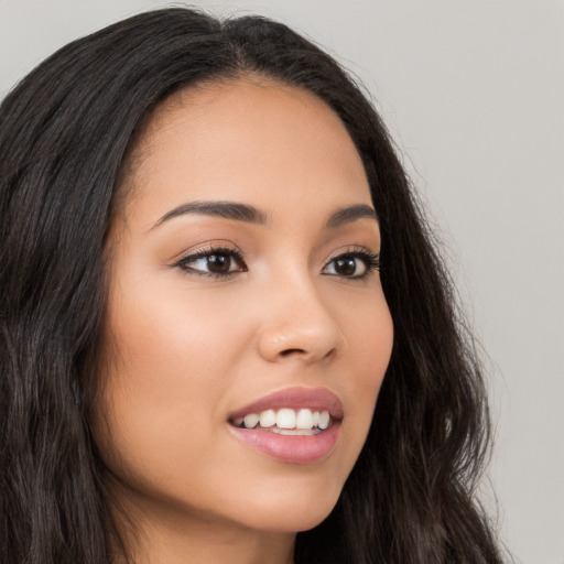 Joyful latino young-adult female with long  brown hair and brown eyes