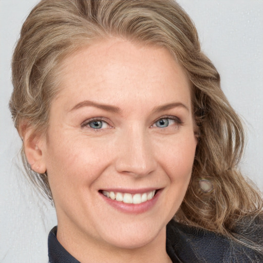 Joyful white adult female with medium  brown hair and blue eyes