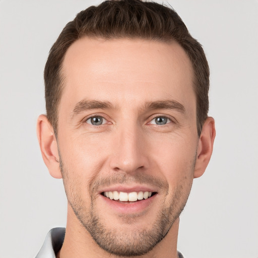 Joyful white young-adult male with short  brown hair and grey eyes