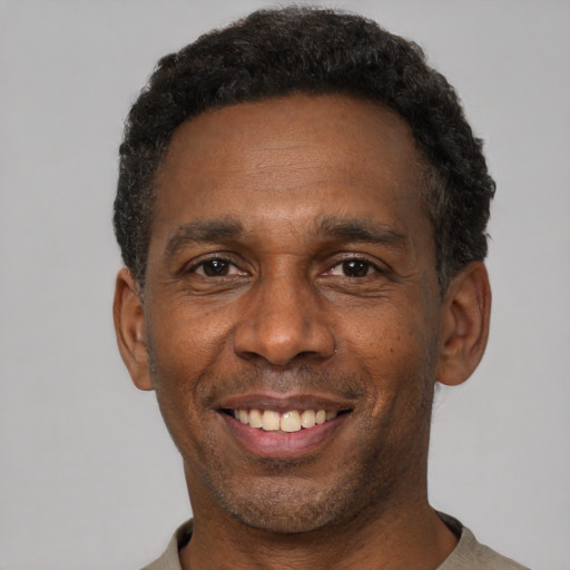 Joyful black young-adult male with short  black hair and brown eyes