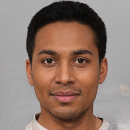 Joyful latino young-adult male with short  black hair and brown eyes