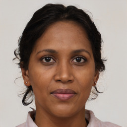 Joyful black adult female with medium  brown hair and brown eyes