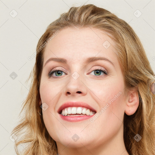 Joyful white young-adult female with long  brown hair and blue eyes