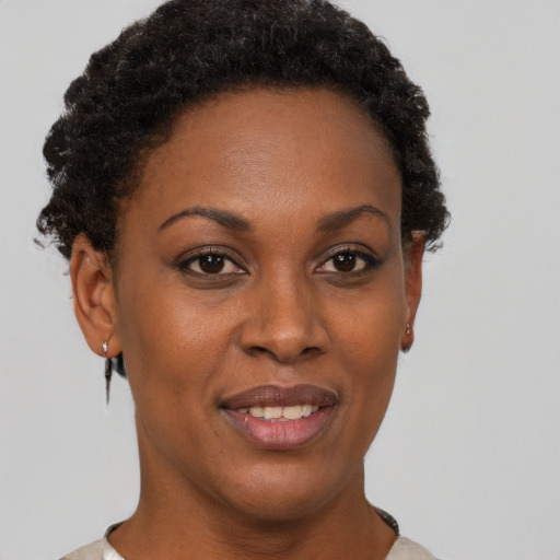 Joyful black young-adult female with short  brown hair and brown eyes