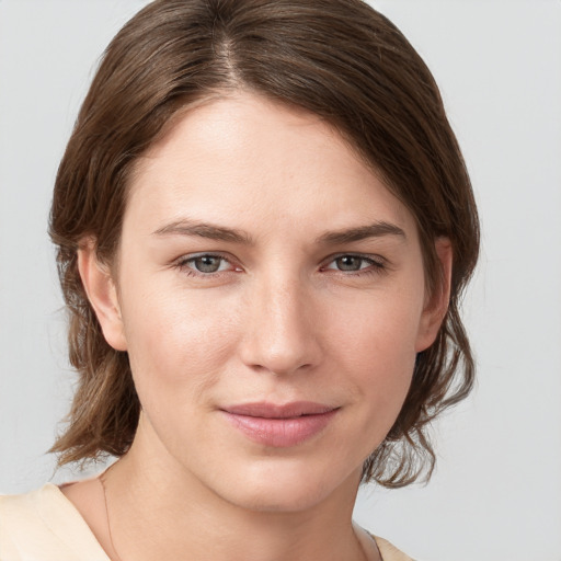 Joyful white young-adult female with medium  brown hair and grey eyes