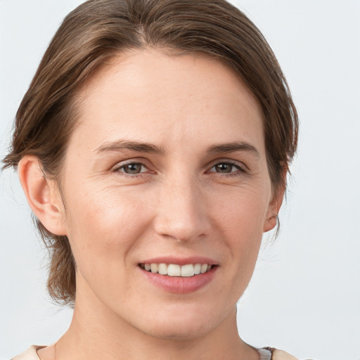 Joyful white young-adult female with medium  brown hair and grey eyes