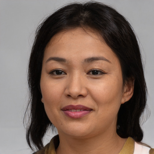Joyful asian young-adult female with medium  brown hair and brown eyes