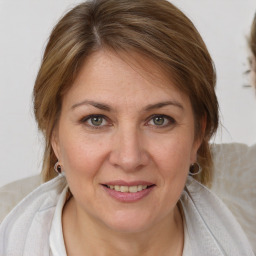 Joyful white adult female with medium  brown hair and blue eyes