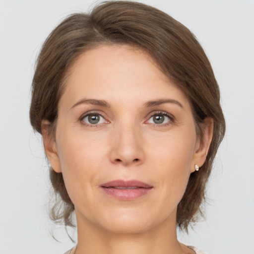 Joyful white young-adult female with medium  brown hair and grey eyes