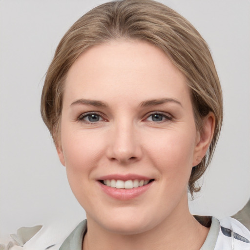 Joyful white young-adult female with medium  brown hair and grey eyes