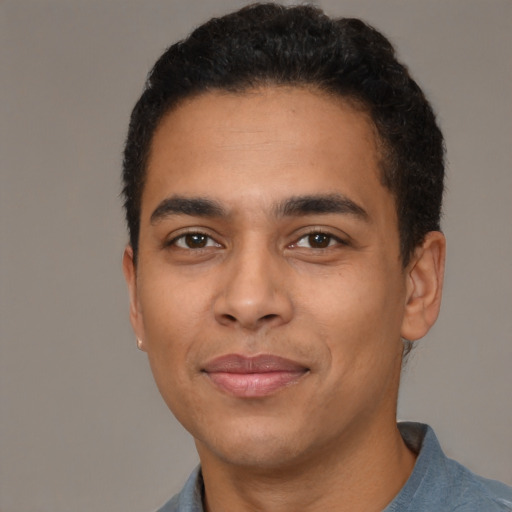 Joyful latino young-adult male with short  brown hair and brown eyes