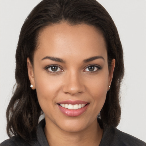 Joyful white young-adult female with long  brown hair and brown eyes