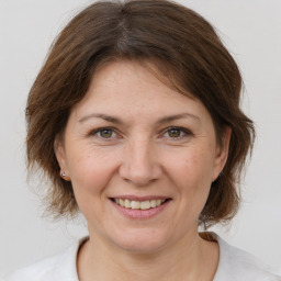 Joyful white adult female with medium  brown hair and brown eyes