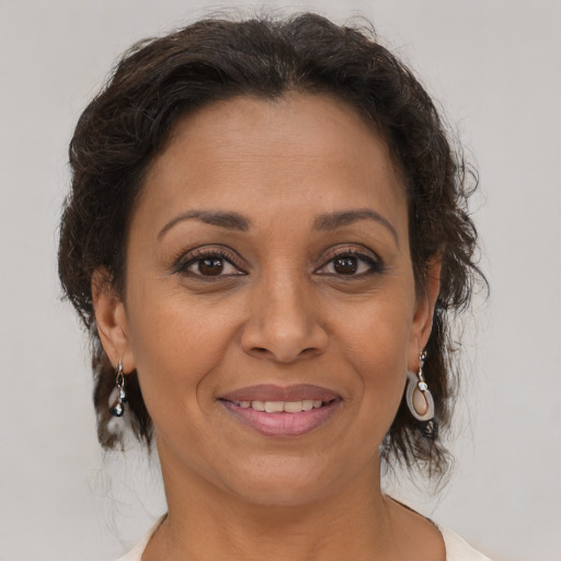 Joyful latino adult female with medium  brown hair and brown eyes